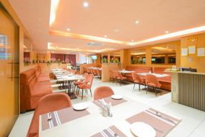 a dining room with tables and chairs in a restaurant at Palette Mahbubabad Railway Station Formerly Hotel RC Platinum in Mahbūbābād