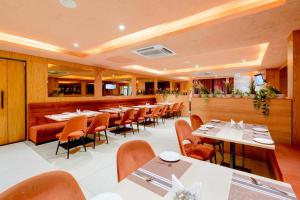 a restaurant with tables and chairs and a bar at Palette Mahbubabad Railway Station Formerly Hotel RC Platinum in Mahbūbābād