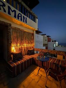 a couch on the side of a building with a table at Jara Cimrmann surf house in Imsouane
