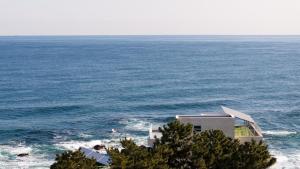 a building on the edge of a body of water at Donghae Badadam Ocean View Spa Pension in Donghae +1 photo