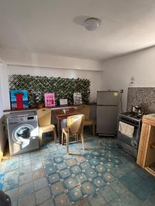 a kitchen with a washing machine and a table and chairs at Jara Cimrmann surf house in Imsouane