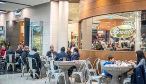 a group of people sitting at tables in a restaurant at ClickClock Hotel in Melbourne