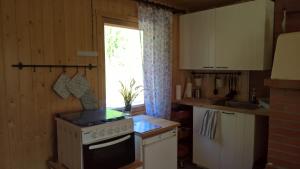 a kitchen with a stove and a window at ILO103 in Huhus