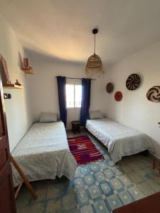a bedroom with two beds and a window at Jara Cimrmann surf house in Imsouane