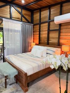 a bedroom with a bed in a room with wooden walls at Arenal Rain Forest Lodge in Fortuna +52 photos