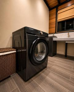 a black washing machine in a kitchen with a counter at Arenal Rain Forest Lodge in Fortuna