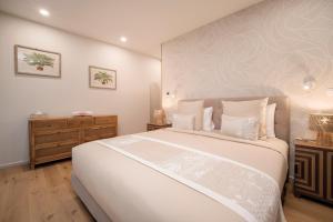 a bedroom with a large white bed and a dresser at APATOA Beach & Garden Village in Raiatea