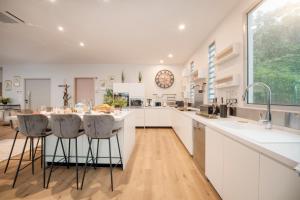 a kitchen with white cabinets and a large island with bar stools at APATOA Beach & Garden Village in Raiatea