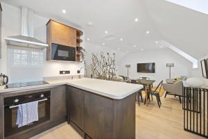 a kitchen with a counter top and a living room at Grange Cottage in Galashiels