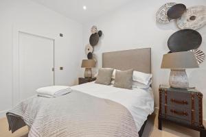 a bedroom with a bed and a night stand with a lamp at Grange Cottage in Galashiels