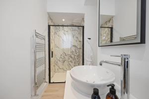 a white bathroom with a sink and a shower at Grange Cottage in Galashiels +10 photos