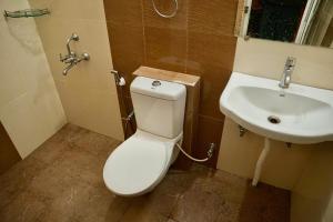 a bathroom with a toilet and a sink at Iyal Hotels and Resorts in Salem +26 photos
