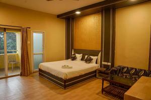 a bedroom with a bed and a couch in it at Iyal Hotels and Resorts in Salem