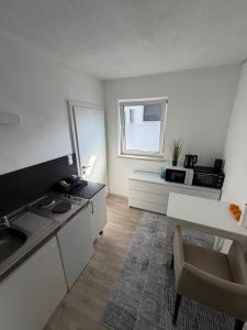 a white kitchen with a sink and a table at Zimmervermietung Wels in Wels
