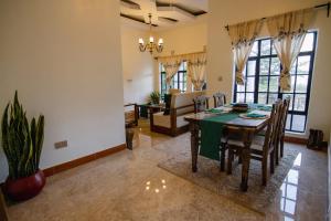 a dining room and living room with a table and chairs at pumzika hill in Arusha