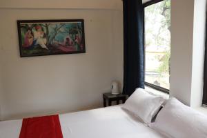 a bedroom with a white bed with a painting on the wall at Desert Nights in Mandāwa