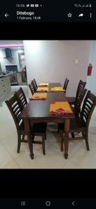 a dining room table with chairs and a wooden table with at Bosago lodge and Spa in Burgersfort