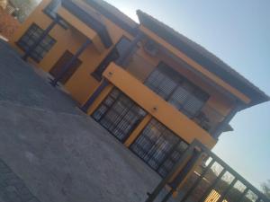 a yellow house with a fence in front of it at Bosago lodge and Spa in Burgersfort