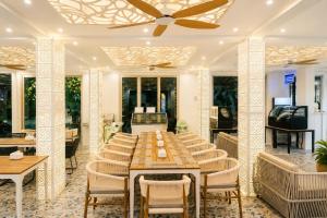 a dining room with a long table and chairs at Avyanna Gulhi Beach Hotel in Gulhi