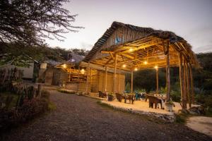 a wooden pavilion with tables in a yard at night at pumzika hill in Arusha