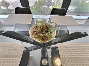 a table with a bowl of salad and two glasses on it at Modern 1BR Views in Belconnen in Belconnen +2 photos