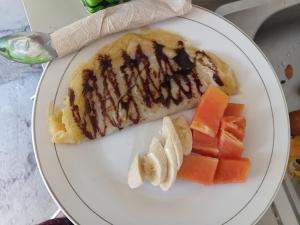 a plate of food with fruit and a pastry at VIA Homestay 1 in Kuta Lombok +46 photos