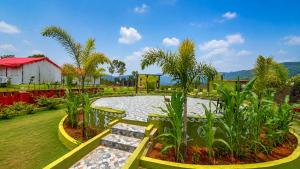a garden with a bench in front of a pond at Sumitel Araku Mount View Camping Resort in Sunkarimetta