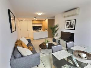 a living room with a couch and a table at Balcony Apt with 1 Bedroom in Belconnen