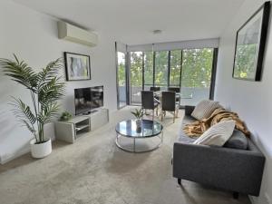 a living room with a couch and a table at Balcony Apt with 1 Bedroom in Belconnen