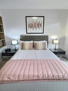 a bedroom with a large bed with two lamps at Balcony Apt with 1 Bedroom in Belconnen +5 photos