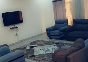 a living room with two couches and a flat screen tv at Zahra Suites in Elephant Island