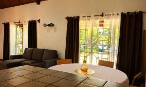 a living room with a table and a couch at Villa de charme in Ivato