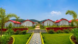 a resort with red and white buildings and palm trees at Sumitel Araku Mount View Camping Resort in Sunkarimetta