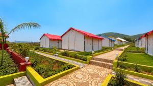 a garden with a row of houses and plants at Sumitel Araku Mount View Camping Resort in Sunkarimetta