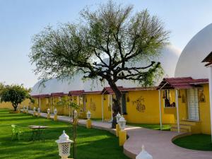 a row of buildings with a tree in the middle at Desert Nights in Mandāwa