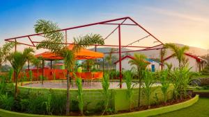 a pavilion with tables and chairs in a garden at Sumitel Araku Mount View Camping Resort in Sunkarimetta