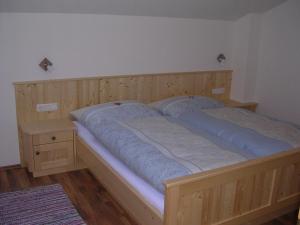 ein Holzbett mit zwei Kissen darauf in der Unterkunft Honsahof in Strassen