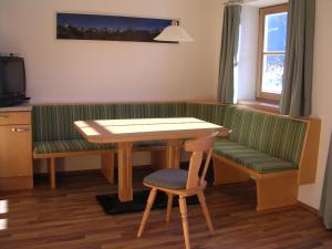 ein Wohnzimmer mit einem Tisch und einer grünen Bank in der Unterkunft Honsahof in Strassen