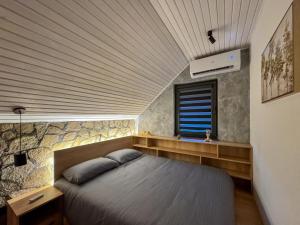 a bedroom with a bed with a wooden ceiling at Lux House in Hadžići