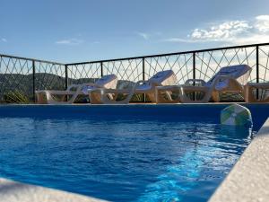 a swimming pool with lounge chairs at Lux House in Hadžići