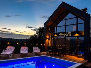 a villa with a swimming pool and a house at Lux House in Hadžići