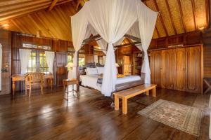a bedroom with a bed and a table and chairs at Secret Moon Beach House in Jasri