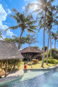 a child swimming in a pool at a resort at Secret Moon Beach House in Jasri