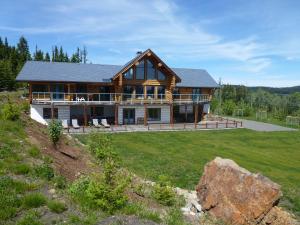 a large log house with a large yard at Little Black Bear Lodge/B&B in Bridge Lake
