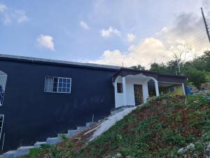a blue house with stairs leading up to it at Round Hill View Heights in Pedro Cross