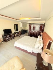 a hotel room with a bed and a couch at CT Suite in Pattaya South