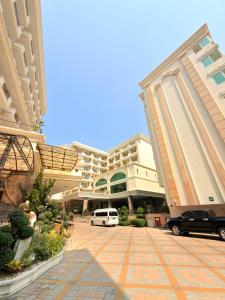 a large building with cars parked in front of it at CT Suite in Pattaya South