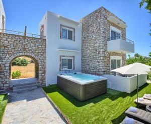 a villa with a hot tub in a yard at G&K Stone Suites in Haraki