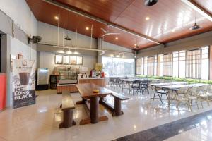 a large room with tables and chairs and a kitchen at Urbanview Hotel Delima 101 Syariah in Serang
