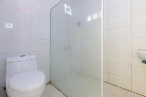 a bathroom with a white toilet and a shower at Urbanview Hotel Delima 101 Syariah in Serang +24 photos